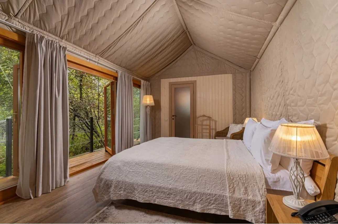 Luxury glamping bedroom with panoramic windows and custom interior configuration